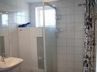 Dusch med helkaklade väggar, golvvärme och klinkergolv.
